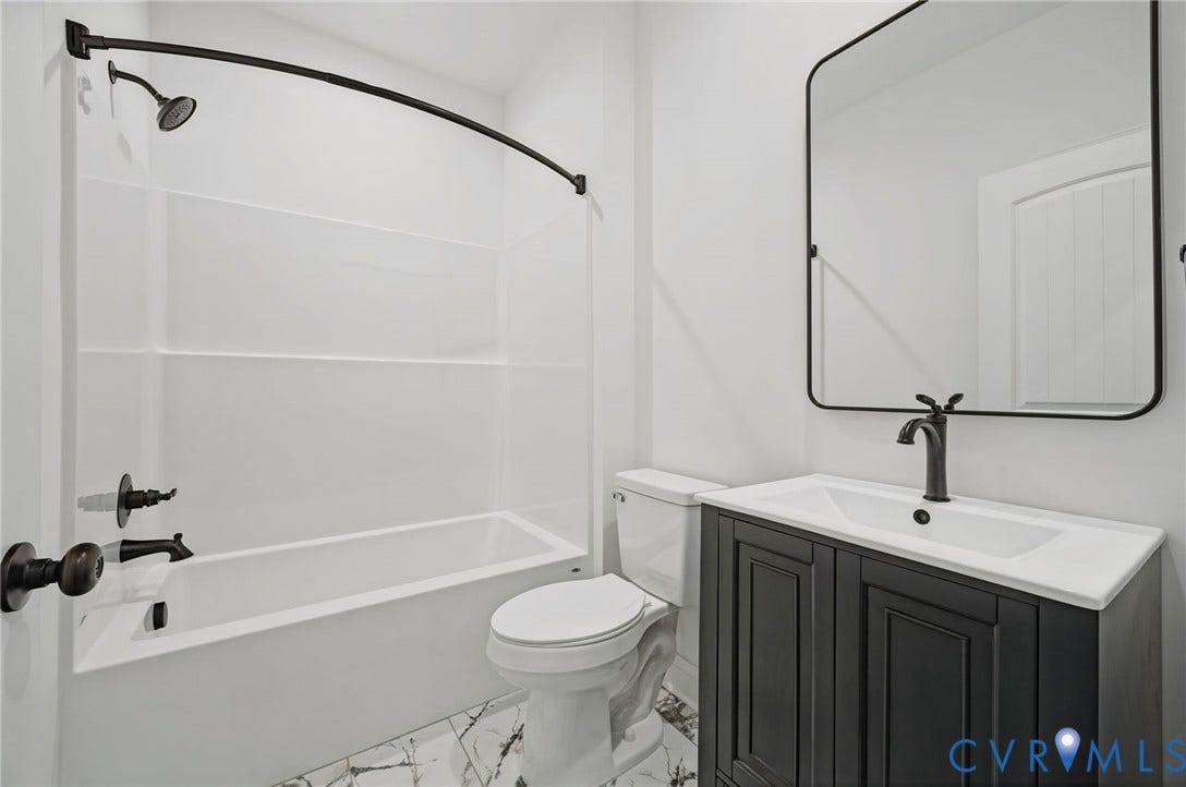 6995 Jefferson Highway, Louisa, VA 23117 Bathroom featuring a white tub/shower combination with dark bronze fixtures, a dark bronze curved shower rod, and a white one-piece toilet