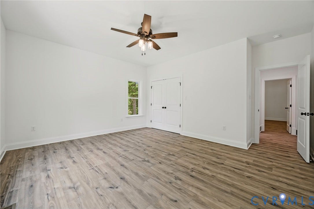 6995 Jefferson Highway, Louisa, VA 23117 Spacious interior featuring wood-finish flooring, crisp white walls, a ceiling fan with integrated lighting, and white bi-fold doors