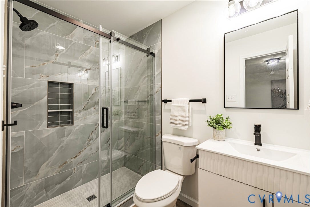 1514 Custer Street, Richmond, VA 23222 Bathroom featuring a walk-in shower with gray marbled tile, a glass sliding door, and a built-in shower niche