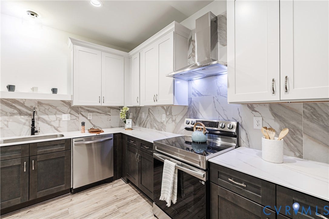 1514 Custer Street, Richmond, VA 23222 Contemporary kitchen featuring two-tone cabinetry, stainless steel appliances, marble-effect quartz countertops, and a full-height marble-effect backsplash