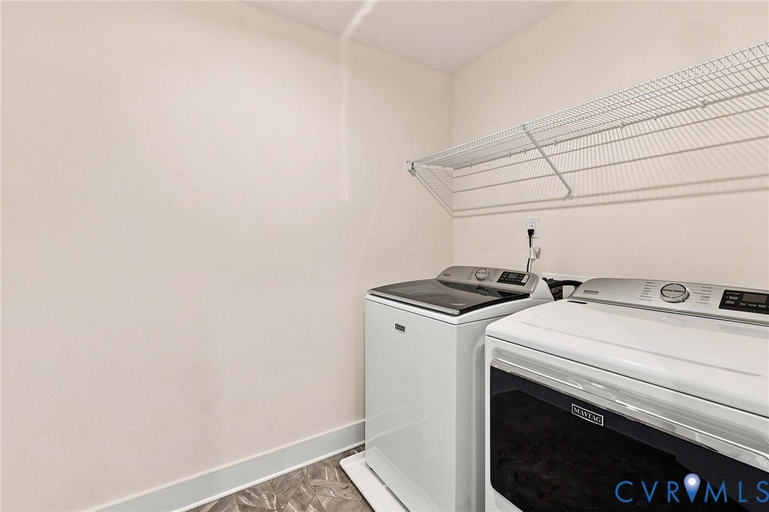 Laundry area featuring a wire storage shelf and light-toned walls