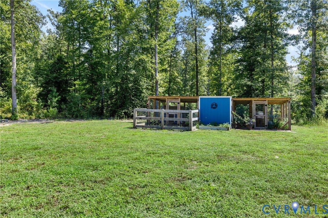 Expansive green lawn with a wooded backdrop