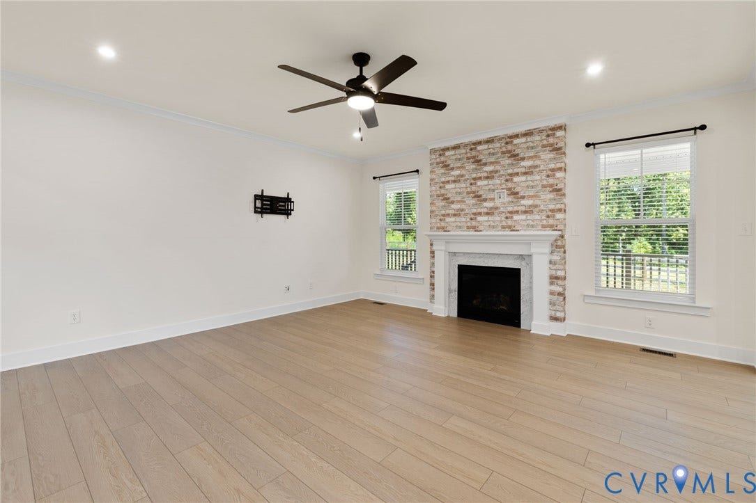 Wood-finish flooring throughout, complemented by a fireplace with a white mantel