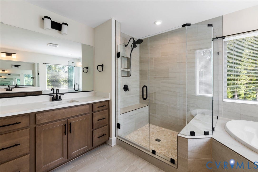 2nd floor primary ensuite. Spacious bathroom featuring a double vanity with ample storage, a large mirror, a walk-in shower with glass enclosure and bench, and a built-in soaking tub