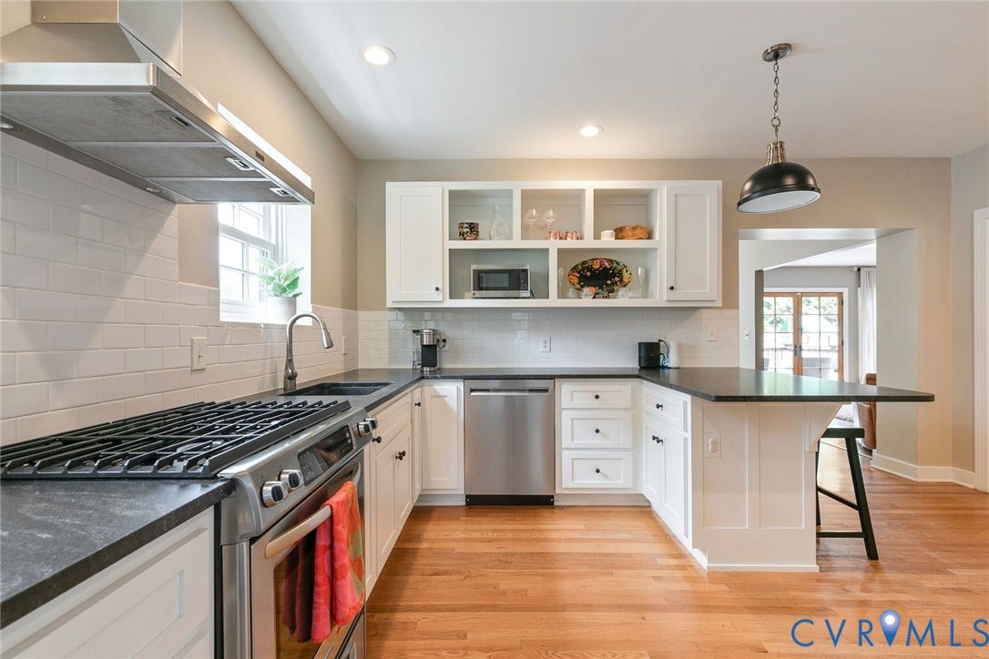 14 Libbie Avenue, Libbie/Grove, Richmond, VA 23226 U-shaped kitchen featuring white cabinetry, dark countertops, stainless steel appliances, a subway tile backsplash, and light wood-finish flooring