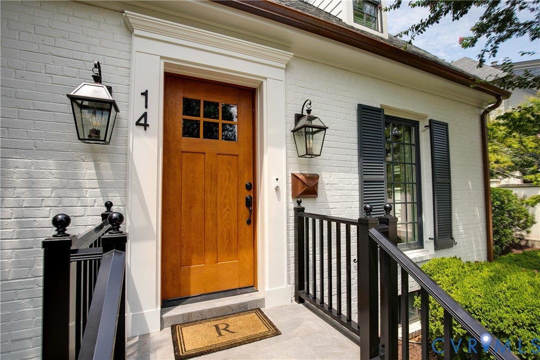 14 Libbie Avenue, Libbie/Grove, Richmond, VA 23226 White brick exterior with a natural wood-finish front door, accented by black louvered shutters and exterior lanterns