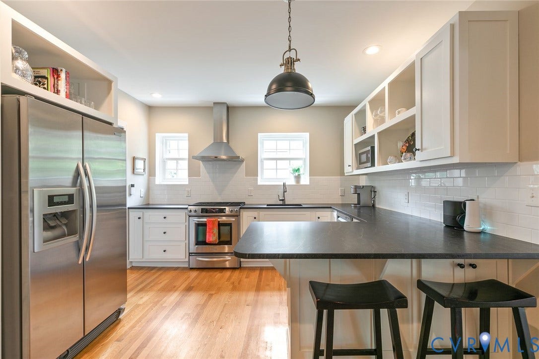 14 Libbie Avenue, Libbie/Grove, Richmond, VA 23226 Kitchen featuring wood-finish flooring, white cabinetry, a large stainless steel refrigerator, and a U-shaped dark countertop with a breakfast bar