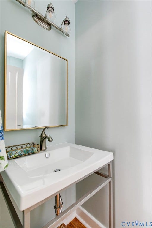 14 Libbie Avenue, Libbie/Grove, Richmond, VA 23226 Pedestal sink with brushed nickel faucet, large wall mirror with gold-tone frame, and brushed nickel vanity lighting