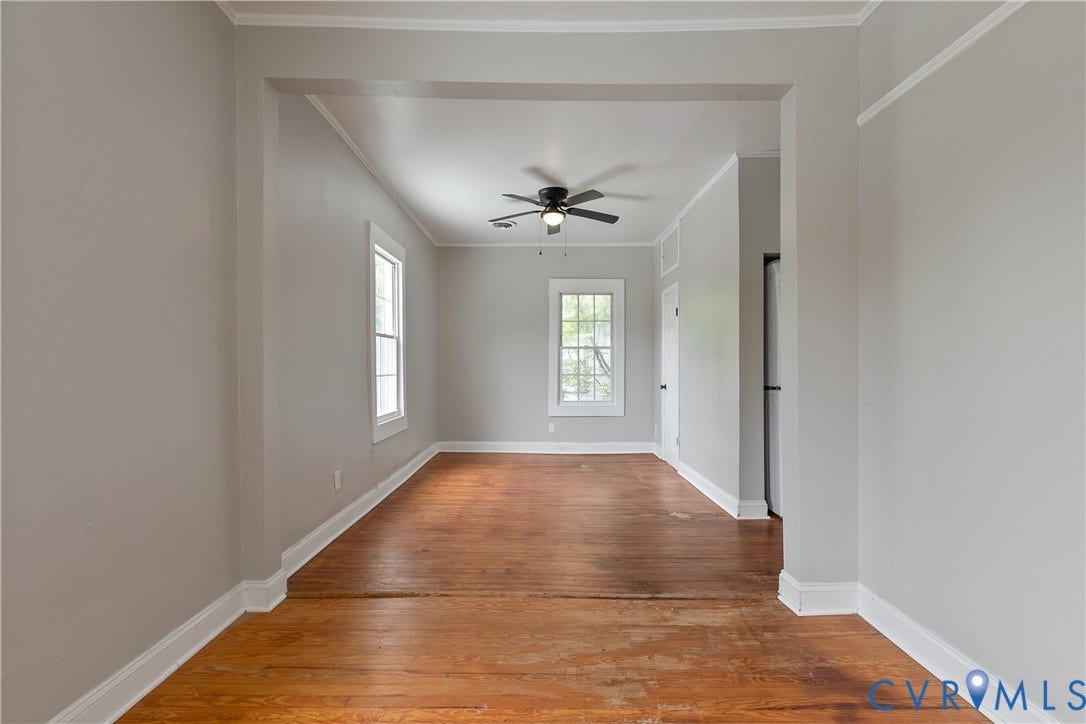 2801 4th Avenue, Richmond, VA 23222 Spacious room featuring wood-finish flooring, light grey walls, white trim, a ceiling fan, and multiple windows allowing natural light