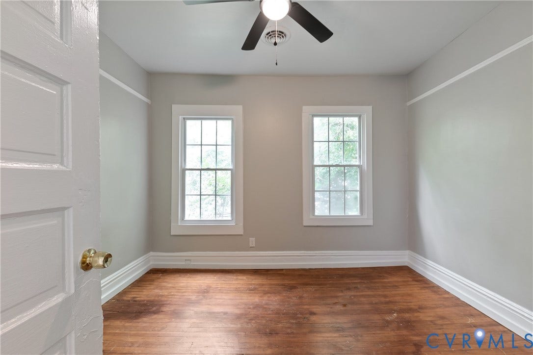 2801 4th Avenue, Richmond, VA 23222 Room featuring wood-finish flooring, two large windows with grid panes, a ceiling fan, and white trim details