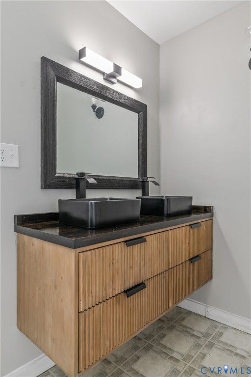 2801 4th Avenue, Richmond, VA 23222 Floating dual vanity featuring a textured wood-finish facade, black vessel sinks, and a dark countertop