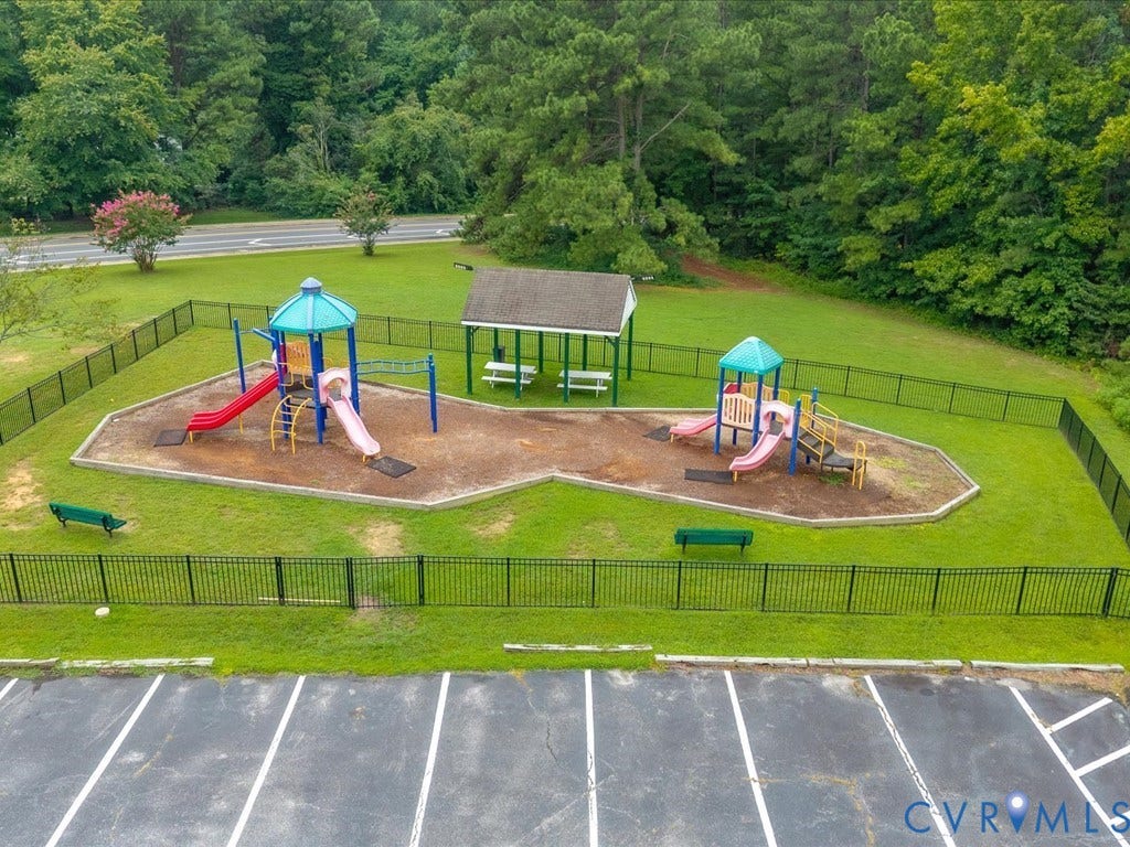 508 Smoketree Place, Chesterfield, VA 23236 Fenced recreational grounds featuring dual playground structures with slides and climbing components, wood-fiber surfacing, picnic table, and mature tree line bordering the perimeter