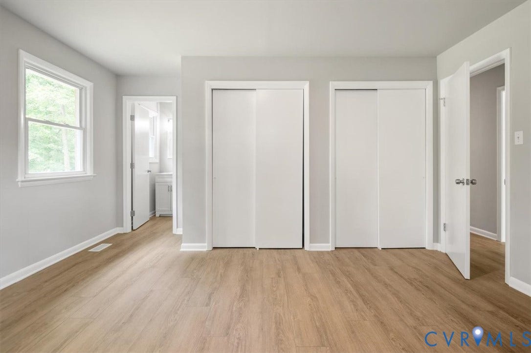 4400 Treely Road, Chesterfield, VA 23831 Spacious room featuring wood-finish flooring, light gray walls, white trim, and two sliding closet doors