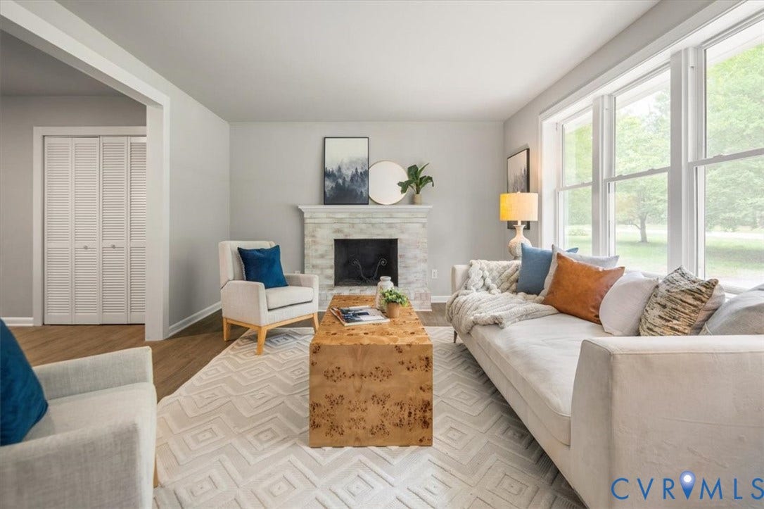 4400 Treely Road, Chesterfield, VA 23831 Living area featuring a fireplace with a light-colored stone surround, light wood-finish flooring, and multiple large windows