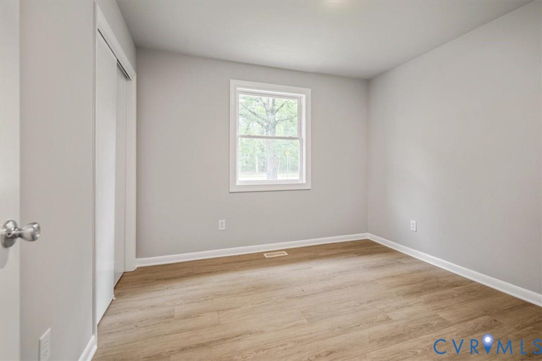 4400 Treely Road, Chesterfield, VA 23831 Neutral-toned interior with wood-finish flooring, a window offering exterior views, and a closet with a sliding door