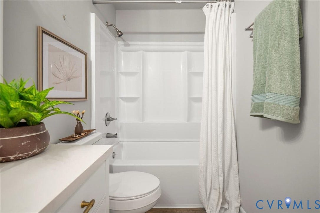 4400 Treely Road, Chesterfield, VA 23831 White shower/tub combination with integrated shelving, chrome fixtures, and a coordinating white shower curtain