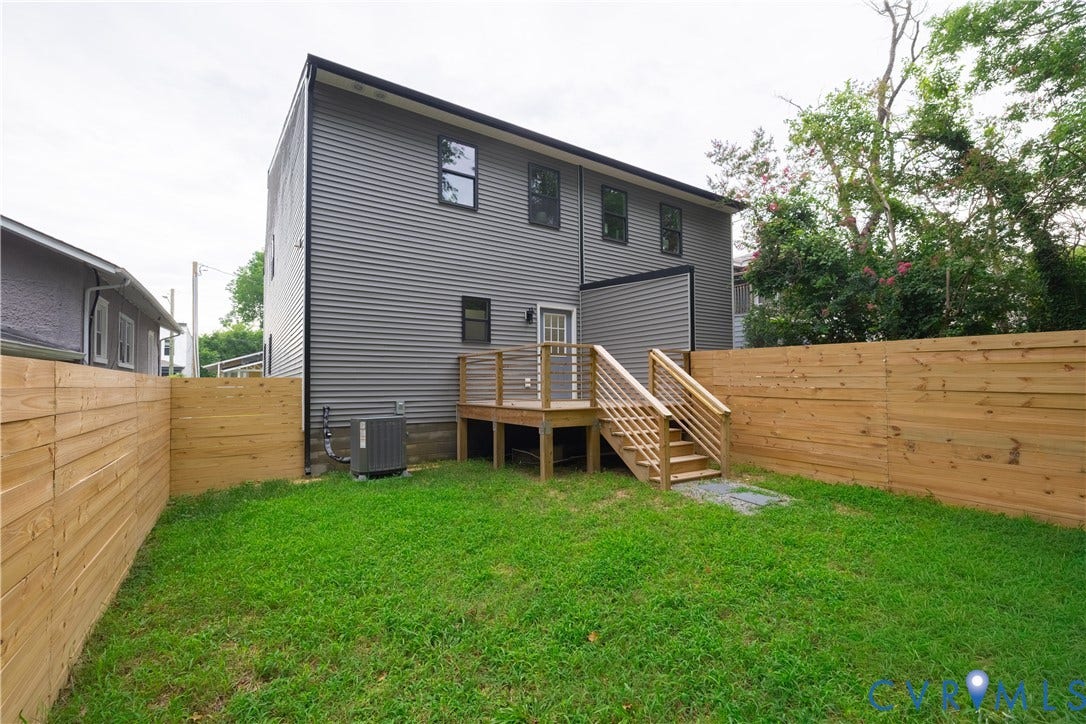 1516 Custer Street, Richmond, VA 23222 Expansive green space featuring a wooden privacy fence, a wooden deck with railing, and exterior siding