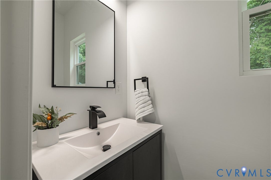 1516 Custer Street, Richmond, VA 23222 Modern vanity featuring a white countertop with an integrated sink, matte black faucet, and a black-framed rectangular mirror