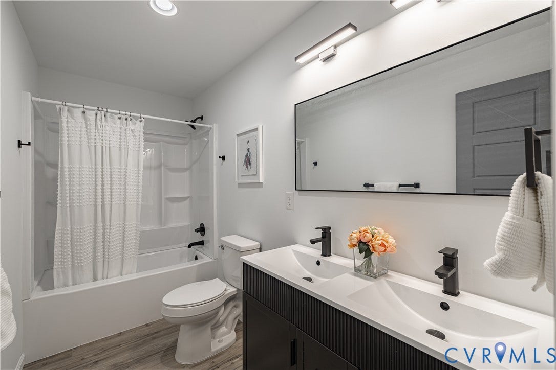 1516 Custer Street, Richmond, VA 23222 Bathroom featuring a dual-sink vanity with matte black fixtures, an integrated white countertop, and a long rectangular mirror