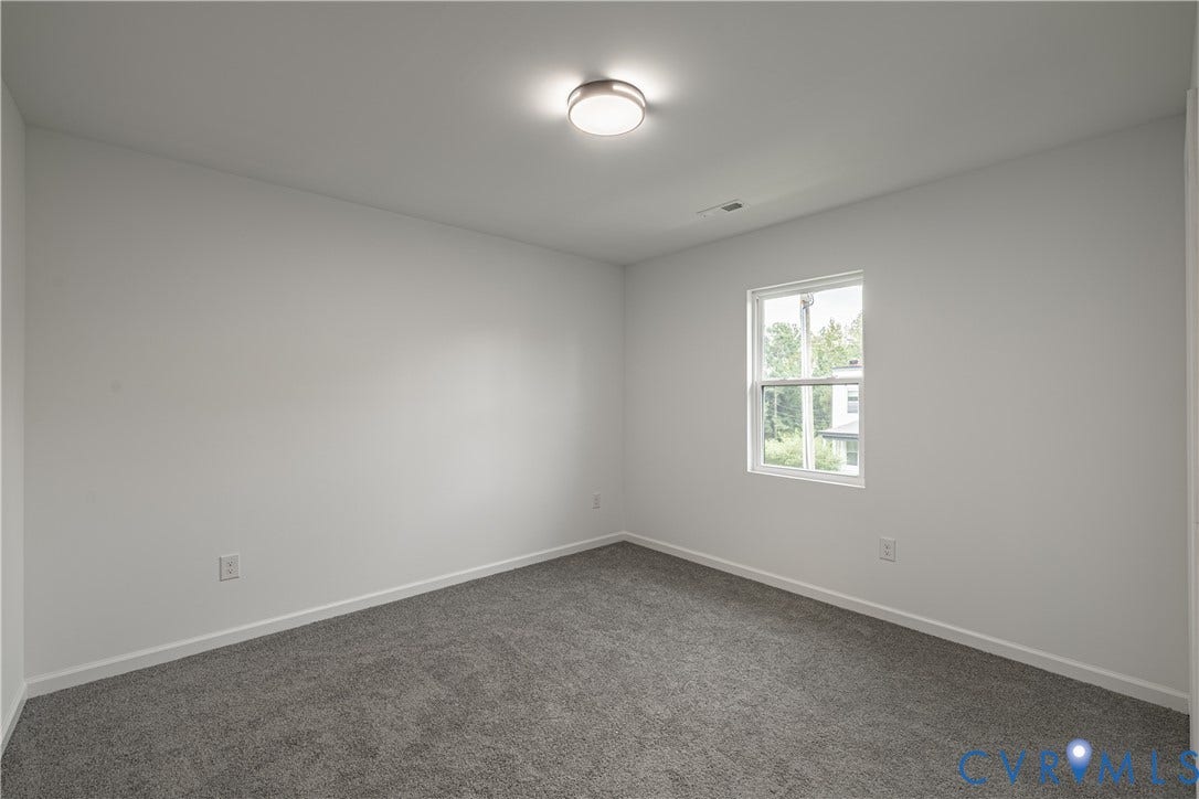 1516 Custer Street, Richmond, VA 23222 Spacious room featuring neutral carpeting, white walls, a double-hung window, and a flush-mount ceiling light fixture