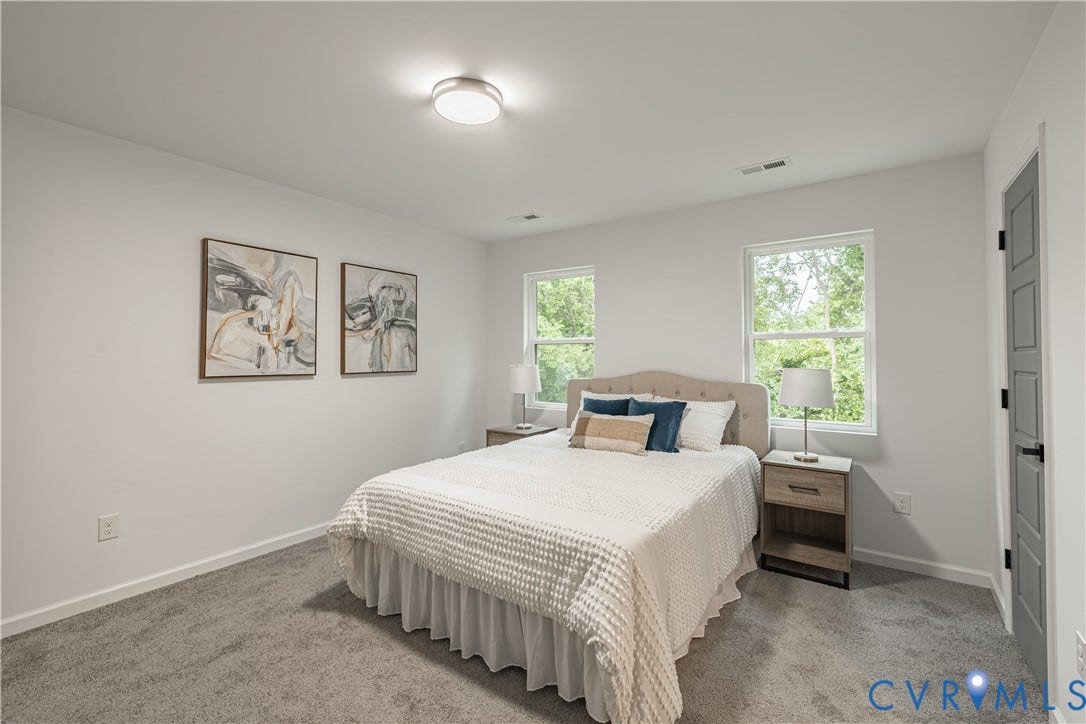 1516 Custer Street, Richmond, VA 23222 Bedroom featuring light gray carpeting, crisp white walls, two double-hung windows, a flush-mount ceiling light fixture, and a paneled door with dark hardware