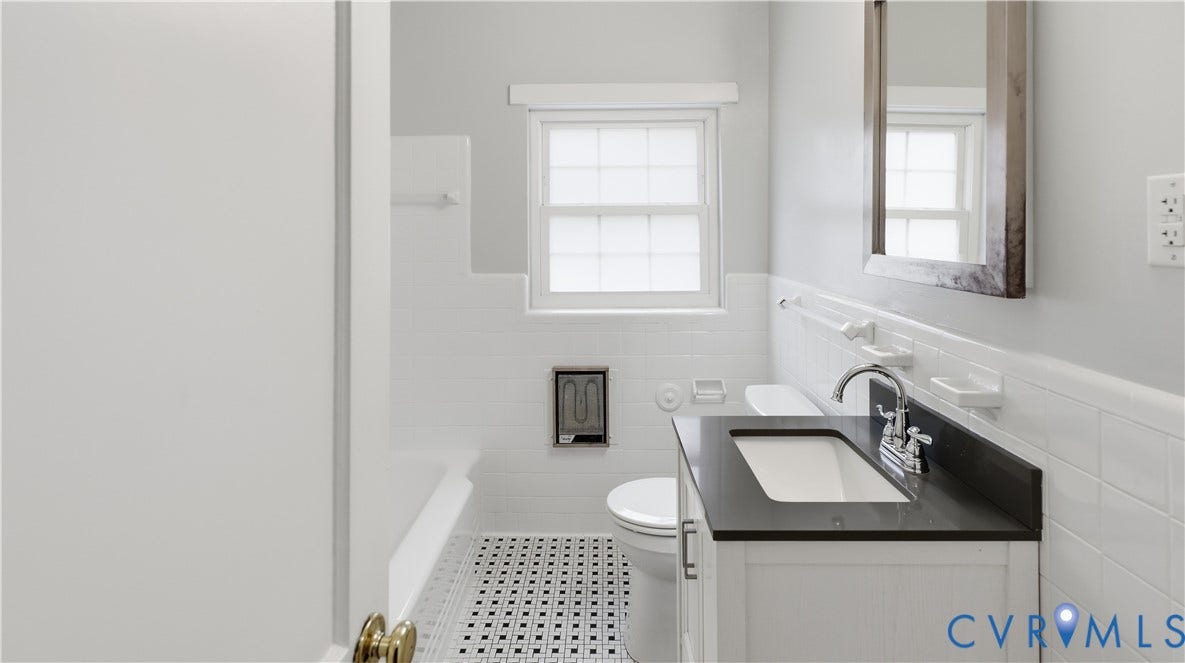 3517 Hanover Avenue, #B, Museum District, Richmond, VA 23221 Bathroom with white subway tile wainscoting, a dark countertop vanity with an integrated rectangular sink, chrome fixtures, and a black and white mosaic tile floor