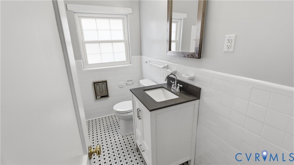 3517 Hanover Avenue, #B, Museum District, Richmond, VA 23221 Bathroom featuring a white vanity with a dark countertop, white subway tile wainscoting, and a black and white mosaic tile floor