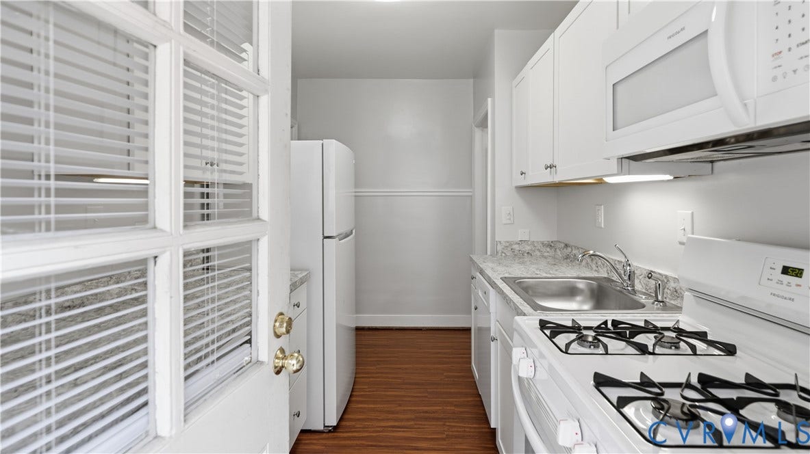 3517 Hanover Avenue, #B, Museum District, Richmond, VA 23221 Galley kitchen featuring white cabinetry, light-toned countertops, and a white appliance suite including a gas range and microwave