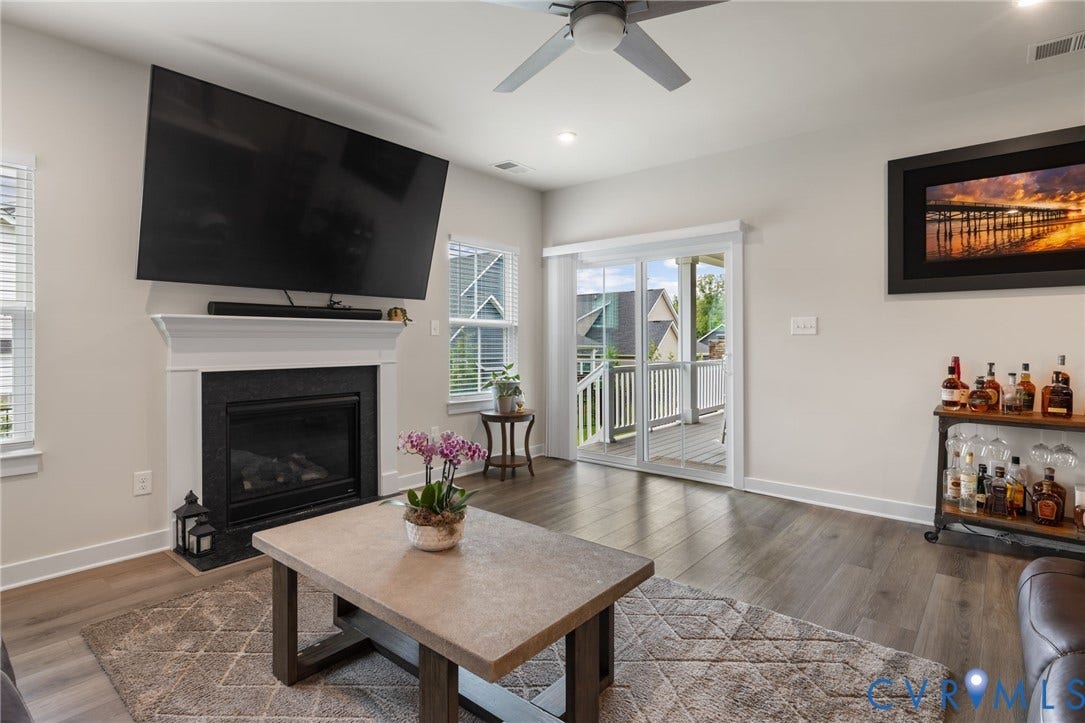 6249 Deer Summit Court, Charleston Club, Moseley, VA 23120 Gas fireplace with a white mantel, LVP flooring, recessed lighting, and doors leading to covered porch