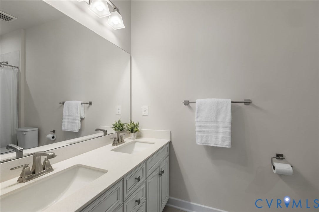 6249 Deer Summit Court, Charleston Club, Moseley, VA 23120 First floor full bathroom with dual vanity with undermount sinks, brushed nickel faucets, and light-toned countertops