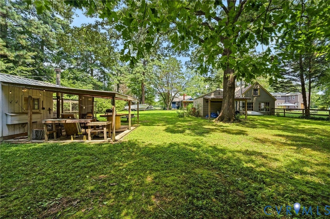 3633 Darbytown Court, Henrico, VA 23231 Expansive green lawn featuring a covered outdoor entertaining area with string lighting and a built-in bar