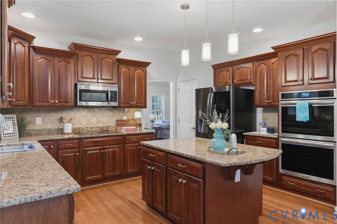 7618 Hampton Green Drive, Chesterfield, VA 23832 Hardwood flooring, wood cabinetry, granite countertops, stainless steel appliances, and a central island with pendant lighting