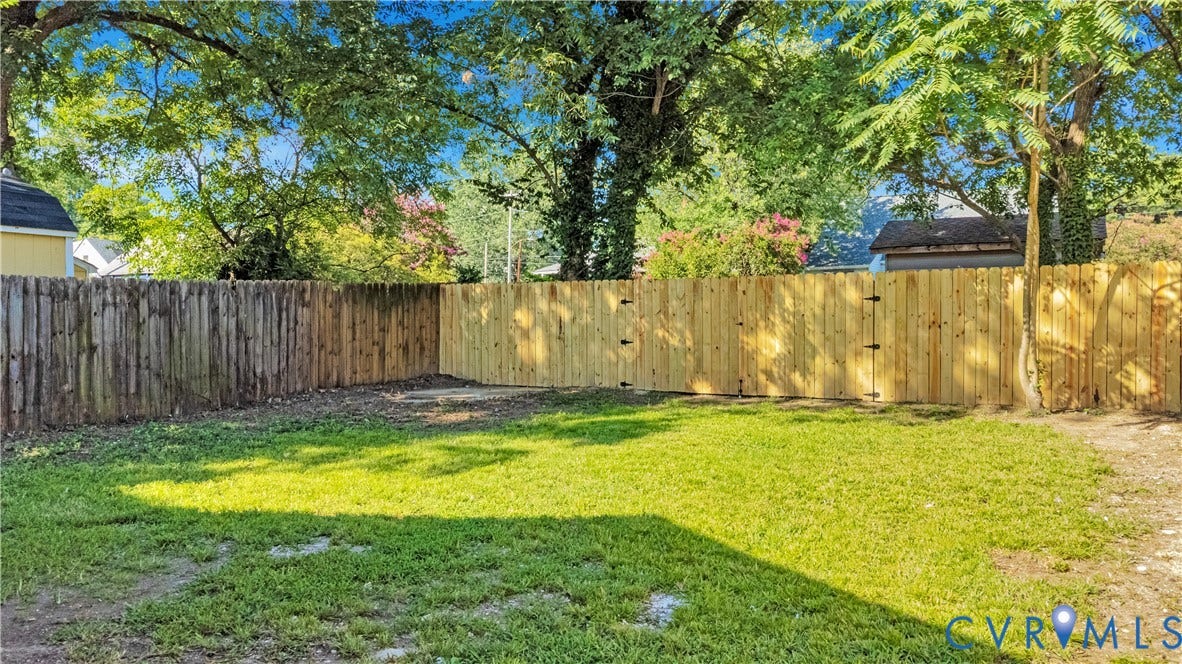 4502 Bunn Avenue, Fulton, Richmond, VA 23231 Expansive backyard featuring a manicured lawn, established perimeter fencing, and mature trees providing natural shade