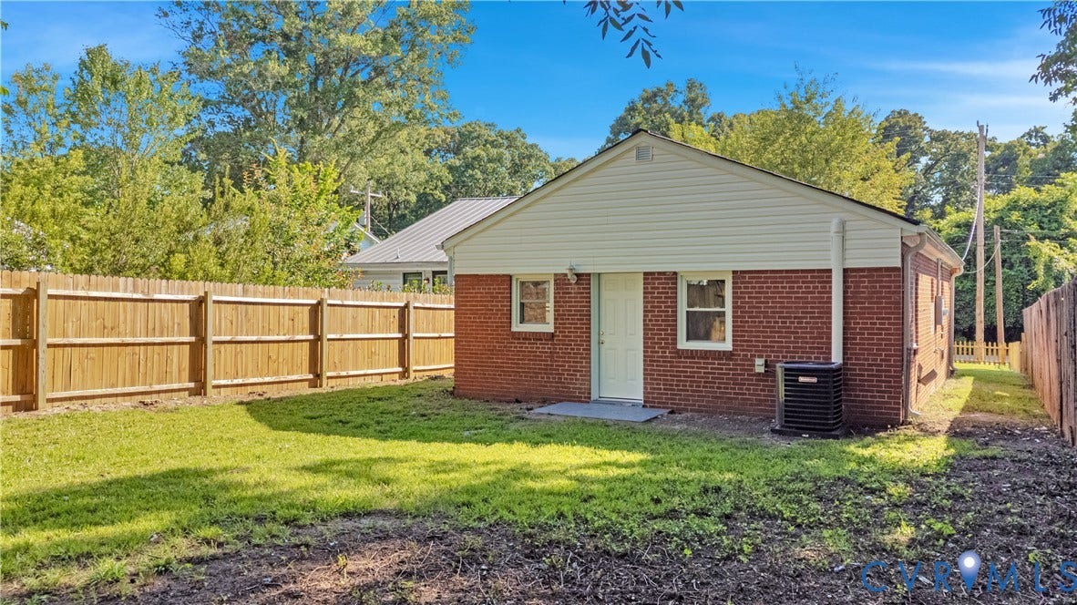4502 Bunn Avenue, Fulton, Richmond, VA 23231 Rear exterior featuring brick and siding construction, a white entry door, two windows, and an air conditioning unit