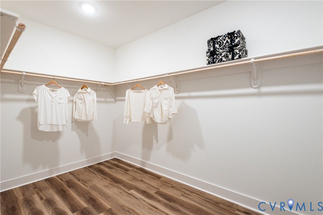 Walk-in closet featuring LVP flooring, extensive built-in shelving, and recessed ceiling lighting