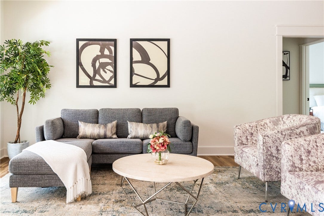 Open-concept living area with light LVP flooring, white baseboards, and a neutral wall color