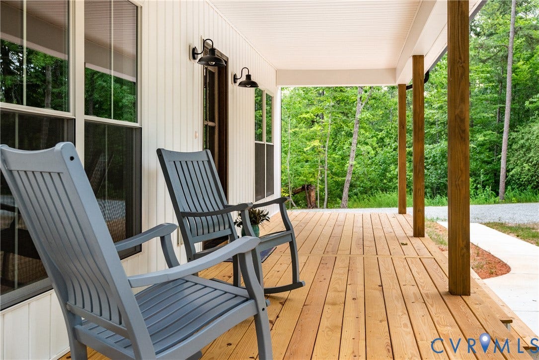 Expansive covered porch featuring natural wood flooring and substantial wood support columns