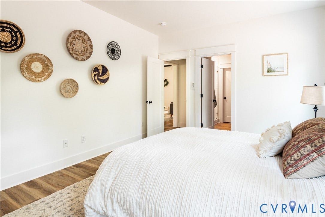 Bedroom featuring LVP flooring, white walls, and bright white trim