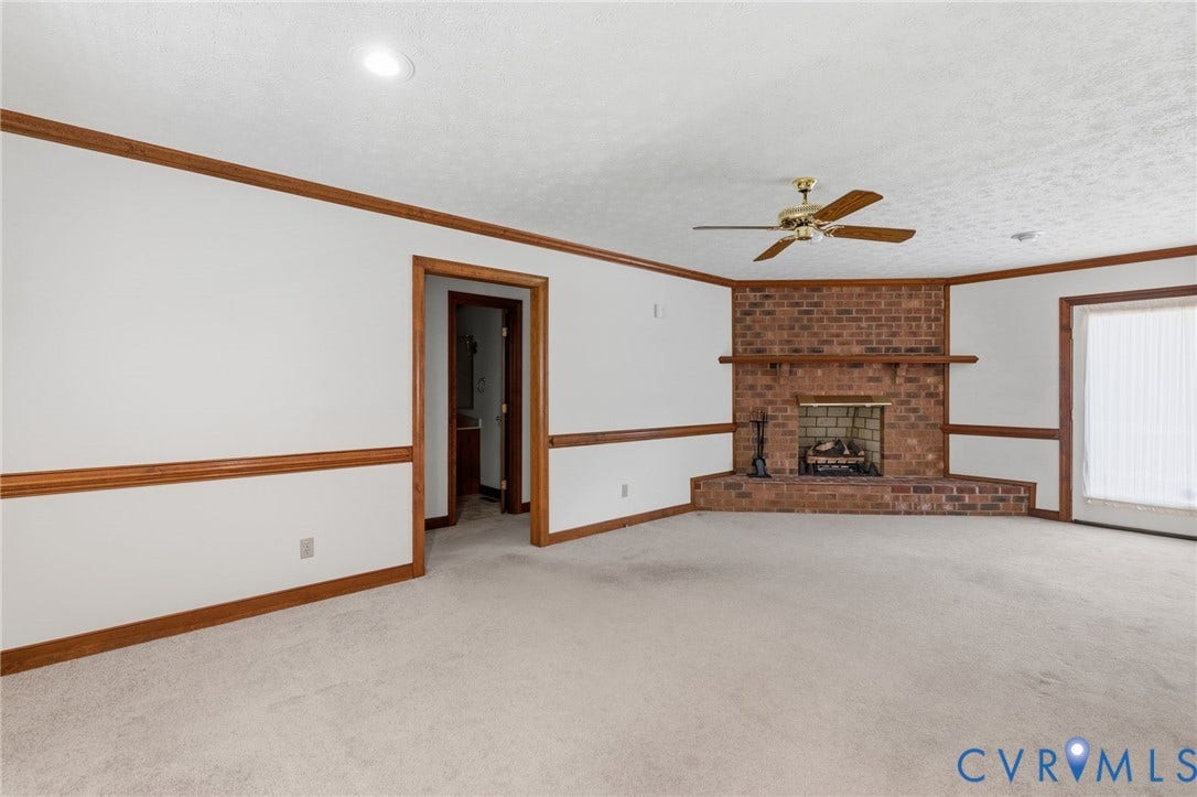 Corner brick fireplace with a wood mantle and hearth