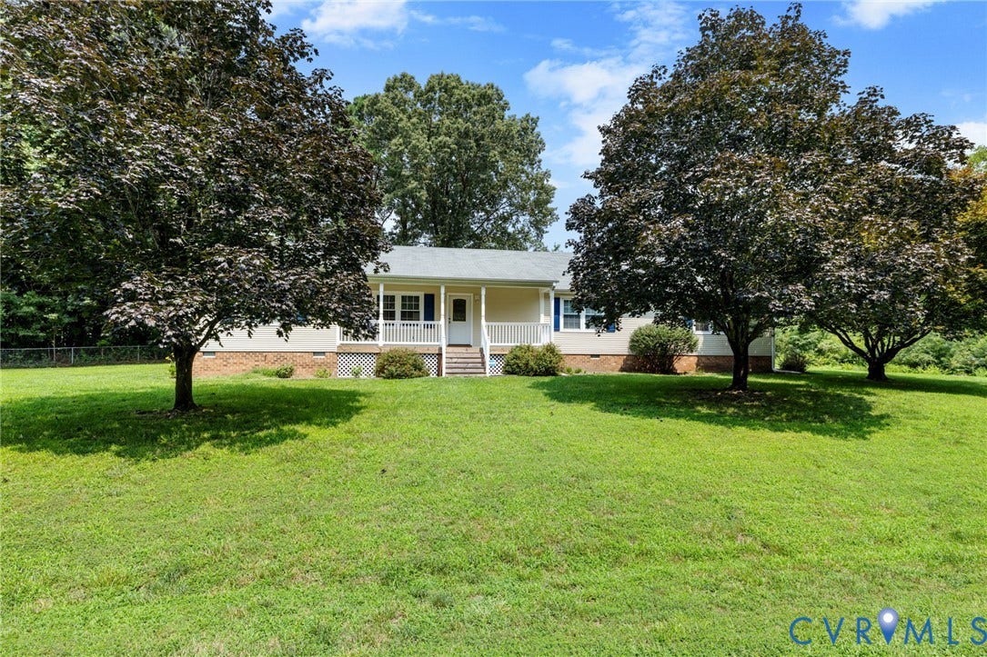 Ranch-style residence featuring a covered front porch with white railings and steps, light-colored siding, and a gabled roof