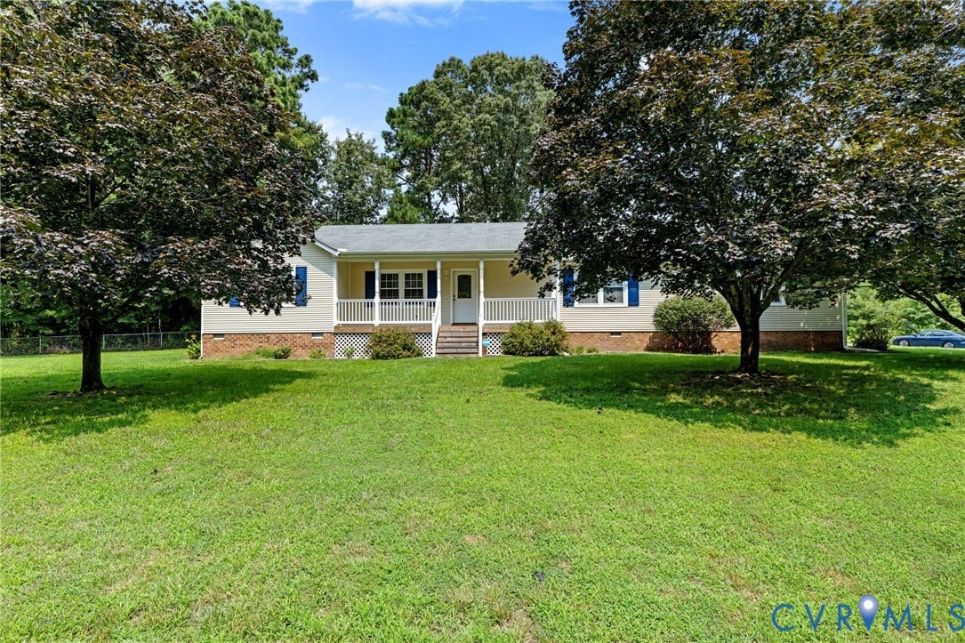 Ranch-style residence featuring a covered front porch, white railings, and steps