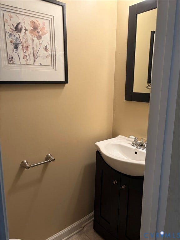 4900 Finnegan Court, Henrico, VA 23228 Powder room featuring a curved corner sink with dark cabinetry, chrome hardware, and neutral wall finishes