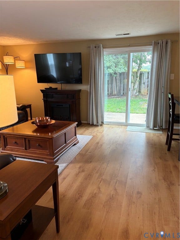 4900 Finnegan Court, Henrico, VA 23228 Wood-finish flooring throughout, featuring a built-in fireplace mantel, and sliding glass doors that open to an outdoor patio area