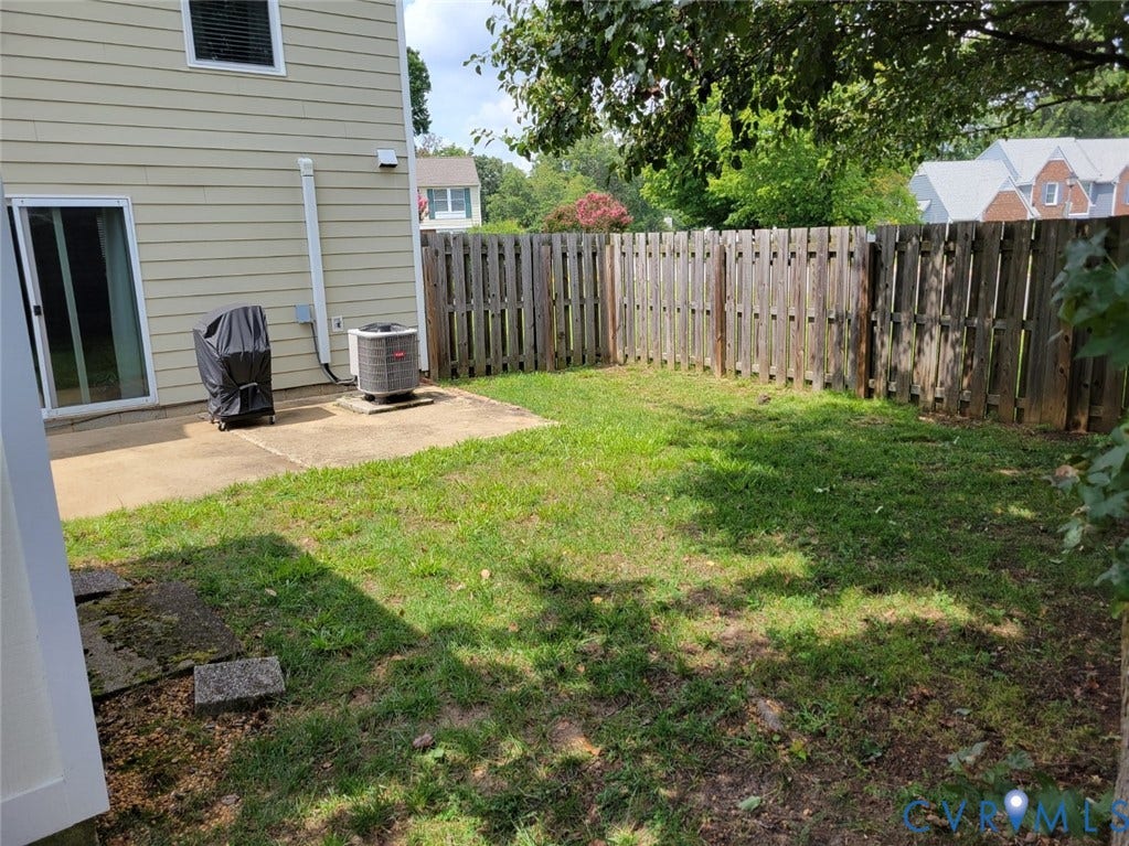 4900 Finnegan Court, Henrico, VA 23228 OVERSIZED Backyard featuring a concrete patio, sliding glass door, wood privacy fence, and grass area