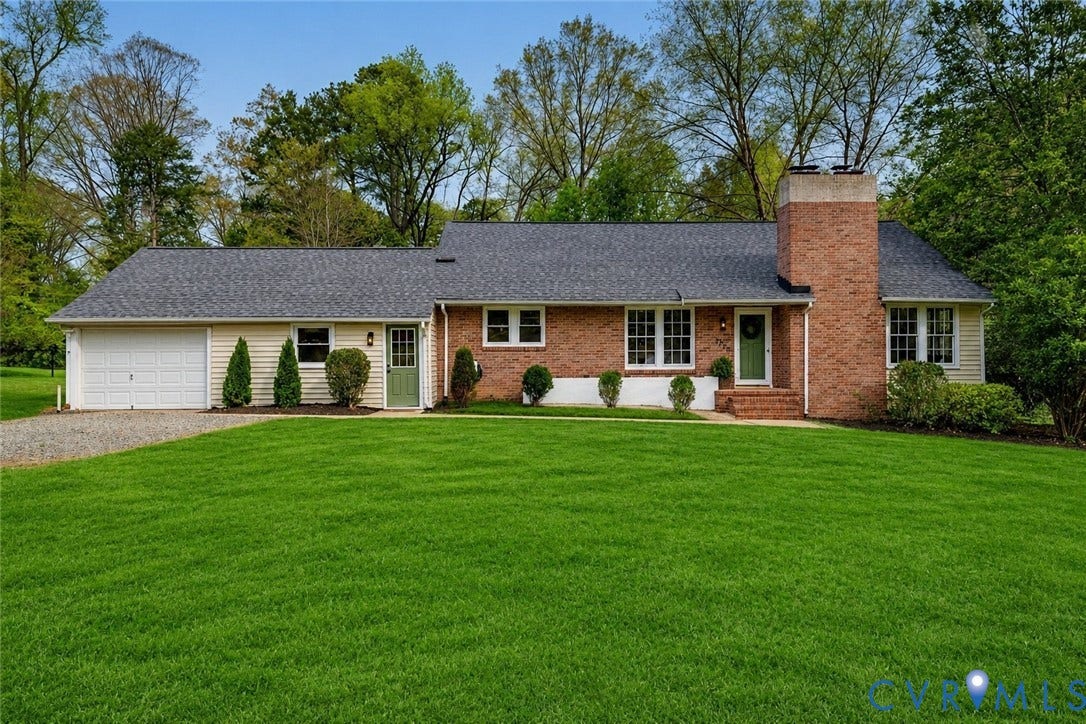 Ranch-style residence featuring a brick and siding exterior, a prominent brick chimney, and a dark shingle roof