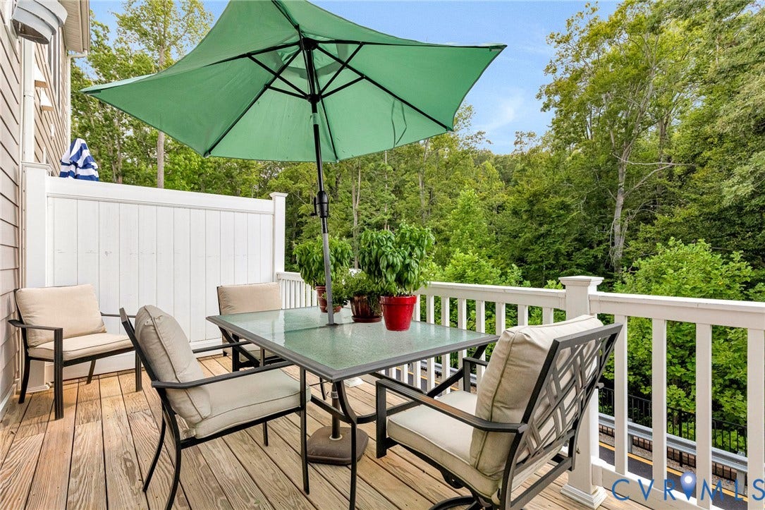 14379 Michaux Village Drive, Winterfield Park, Midlothian, VA 23113 Right outside the family room is this large private outdoor wood-finish deck featuring white spindle railings, a privacy wall, and natural tree surroundings.