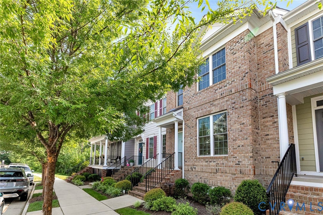 14379 Michaux Village Drive, Winterfield Park, Midlothian, VA 23113 Brick townhouse exterior featuring white trim, a covered porch with white columns, and black metal railings