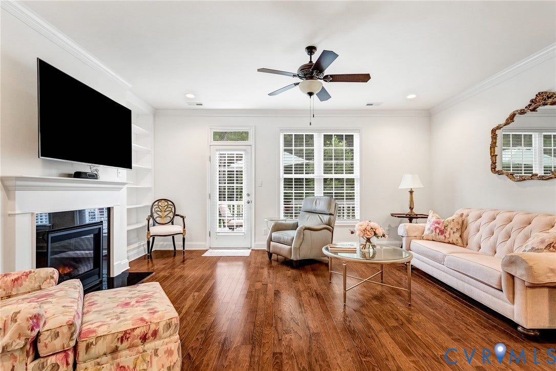 14379 Michaux Village Drive, Winterfield Park, Midlothian, VA 23113 Spacious living area featuring rich wood-finish flooring, a white mantel fireplace, and built-in shelving