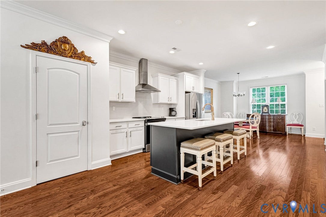 14379 Michaux Village Drive, Winterfield Park, Midlothian, VA 23113 Spacious kitchen featuring a large island with seating, stainless steel appliances, white cabinetry, and rich wood-finish flooring