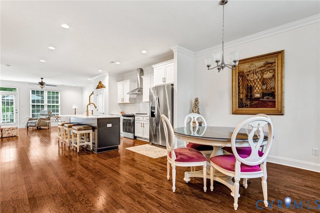 14379 Michaux Village Drive, Winterfield Park, Midlothian, VA 23113 Open-concept living space featuring wood-finish flooring, white cabinetry, a kitchen island with seating, stainless steel appliances, and recessed lighting